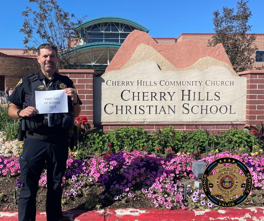 Douglas County Deputy Dan Coyle standing in front of the Cherry Hills Christian School sign on the first day of school. Coyle is the first School Resource Officer to be at the private school.